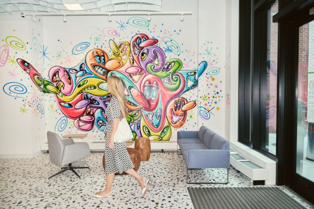 Christine i entr&eacute;n p&aring; Child Mind Institute, d&auml;r Kenny Scharf m&aring;lat en hel v&auml;gg.